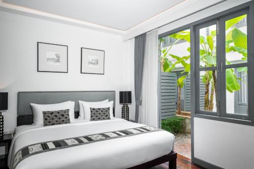 a bedroom with a bed and a window at Souphattra Hotel Luang Prabang in Luang Prabang