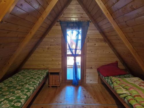 two beds in a room with a window at Noclegi Korbielów in Korbielów