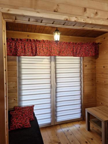 a room with a large window with a blind at Noclegi Korbielów in Korbielów