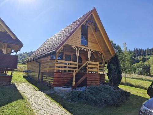 a large wooden cabin with a gambrel roof at Noclegi Korbielów in Korbielów