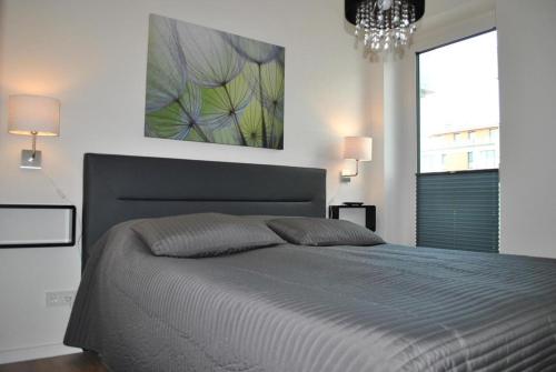 The White Pearl inkl Wäsche Set في هايليغنهافن: غرفة نوم بسرير كبير ولوحة على الحائط