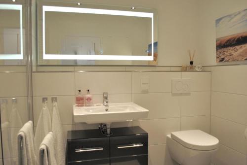 The White Pearl inkl Wäsche Set في هايليغنهافن: حمام أبيض مع حوض ومرحاض