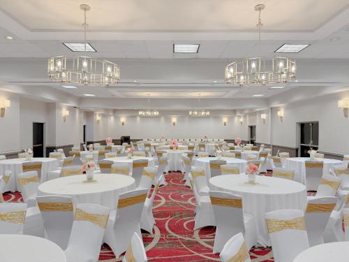 a banquet hall with white tables and chairs and chandeliers at Crowne Plaza Newark Airport by IHG in Elizabeth