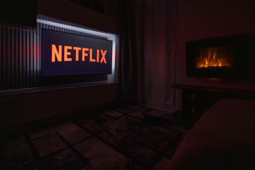 a television in a dark room with a netflix sign at Spazioso appartamento con terrazzo Navigli, Bocconi in Milan