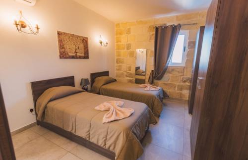 a room with two beds in a room at Villa Mercury in Żejtun