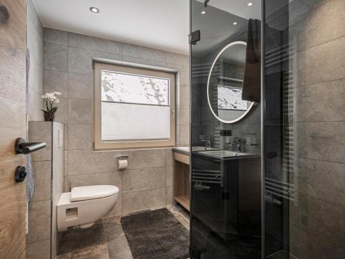 a bathroom with a toilet and a sink and a mirror at Ferienhaus Evelyn in Tux