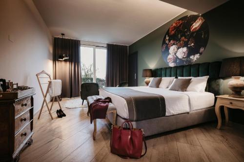 a bedroom with a large bed with a red bag at Relais Almaranto in Calamandrana