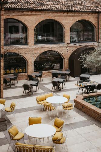 a patio with tables and chairs in front of a building at Relais Almaranto in Calamandrana