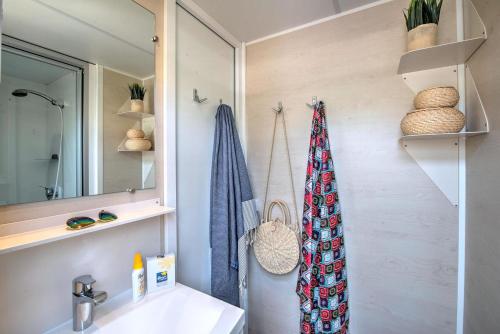 une salle de bain avec un lavabo et un miroir dans l'établissement Domaine Résidentiel de Plein Air Le Bois d'Amour, à Quiberon