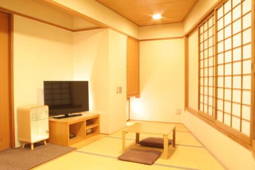 a living room with a television and a coffee table at Hotel Estacion Hikone in Hikone