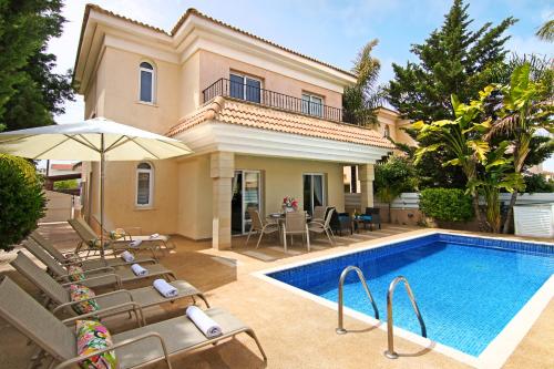 a villa with a swimming pool and a house at Villa Alyson in Paralimni