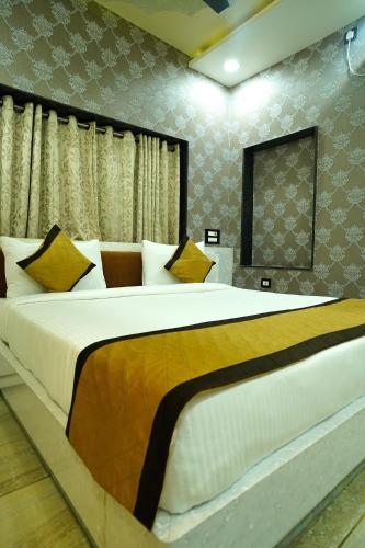 a bedroom with a large bed with yellow and white pillows at THE MANTRA- A Luxury Boutique Hotel in Khagaul