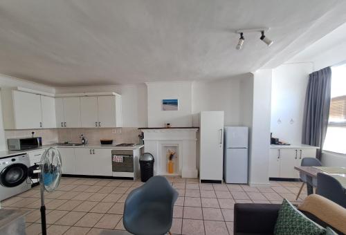 a large kitchen with white cabinets and appliances at Azzure Apartments 4 sleeper Strand in Strand