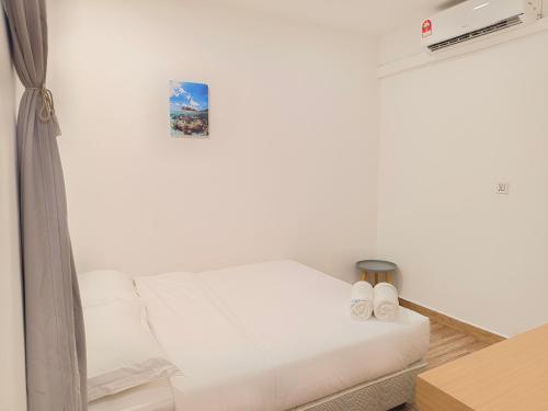 a bedroom with a white bed with two slippers at Shoreline Guesthouse 海岸线客栈 in Semporna