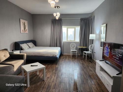 una pequeña sala de estar con cama y TV. en studio with sea view vip, en Ajman