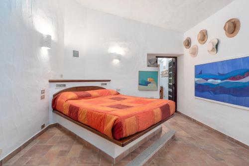a bedroom with a bed and a painting on the wall at Corbezzoli in San Teodoro