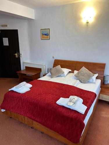 a bedroom with a large bed with towels on it at Vila Condor in Poiana Brasov