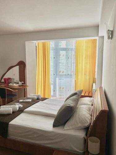 a bedroom with a large bed with a window at Vila Condor in Poiana Brasov