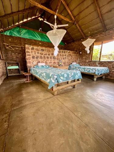 a room with two beds in a brick wall at Kaoxa Bush Camp in Linton