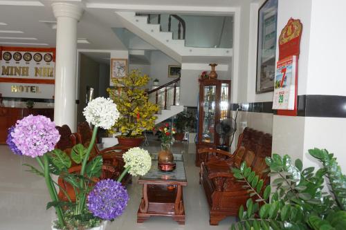a room with vases of flowers on a table at Minh Nhi Hotel in La Gi