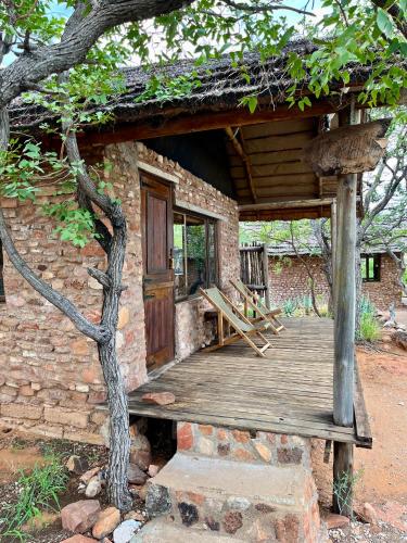 a brick building with a wooden porch and a door at Kaoxa Bush Camp in Linton