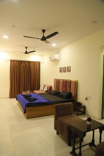 卡尔贾特Ivy Bliss Studio with Common Pool, B 10, Karjat的带一张大床和一张沙发的卧室