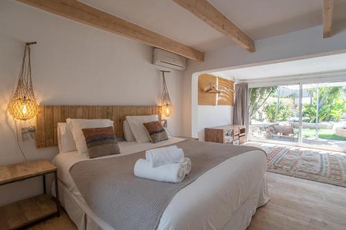 a bedroom with a large bed and a large window at Can Aisha in Es Pujols