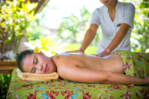 a woman getting a back massage from a man at Saren Indah Hotel in Ubud