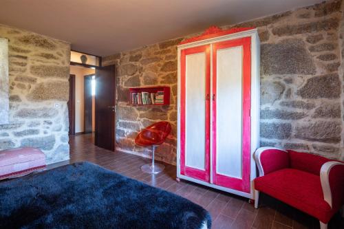 a living room with a red door and a red chair at Chan Da Ra in A Lama