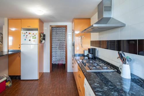 a kitchen with a white refrigerator and a stove top oven at Chan Da Ra in A Lama