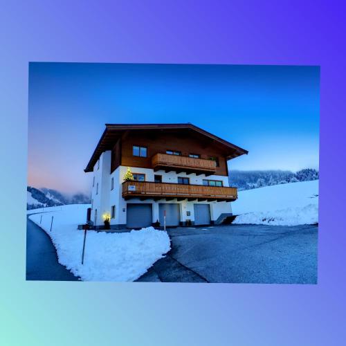 a building with snow on the side of it at Ferienwohnung Lacken in Fieberbrunn