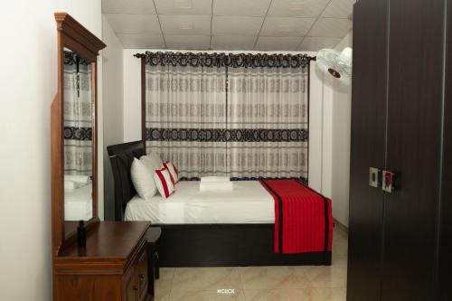 a small bedroom with a bed and a window at Chamil villa in Galle