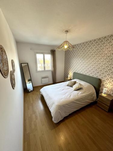 a bedroom with a large white bed and a window at LE PAISIBLE - Parking gratuit - Entrée ville in Jurançon