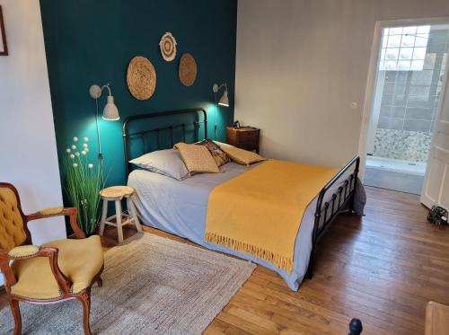 une chambre avec un lit et une chaise dans l'établissement L'Amandine, à Saint-Amand-en-Puisaye