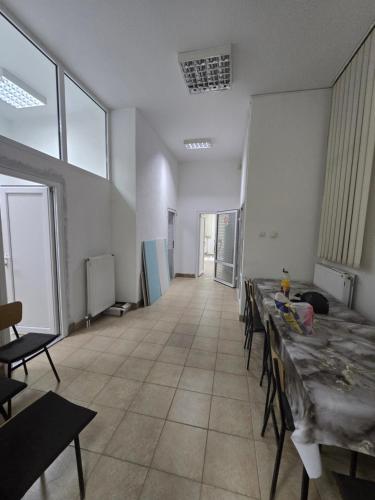 an empty room with tables and chairs and windows at Smestaj za radnike Stadion Lagator Loznica in Loznica