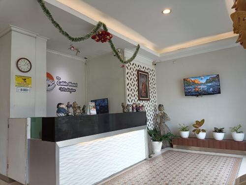 NgabeanにあるThe Cabin Hotel Wirobrajanのロビー(カウンター、壁掛け時計付)