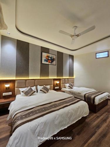 a bedroom with two beds and a ceiling at Hotel Fortune in Ayodhya