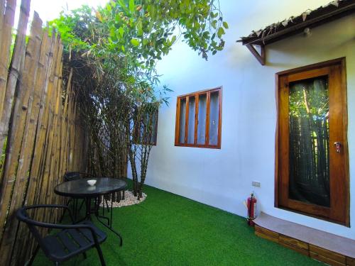 a patio with a table and chairs and a fence at U Story Resort in Siquijor