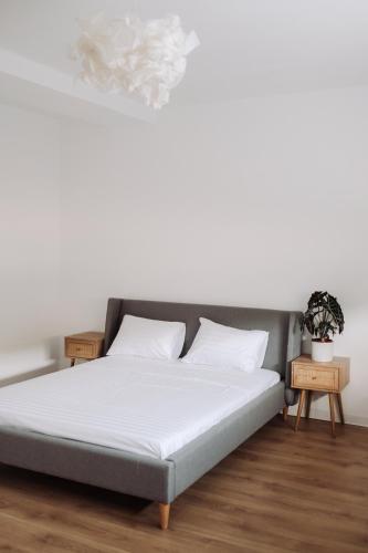 a bed with white sheets and pillows in a room at Snagov Forest Villa in Ciolpani