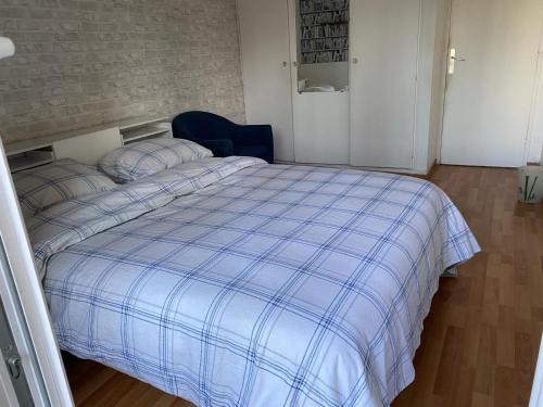 - une chambre dotée d'un lit avec une couverture bleue dans l'établissement Apartment 2 Chambres avec 2 Balcons, Évry-Courcouronnes