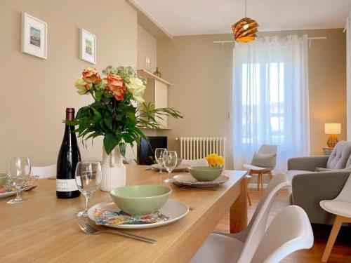 - un salon doté d'une table avec des fleurs et des verres à vin dans l'établissement L'Arche de Noyers, à Noyers-sur-Cher