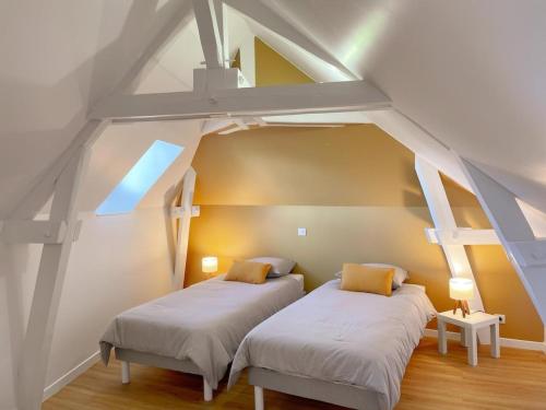 - 2 lits dans une chambre avec un toit dans l'établissement L'Arche de Noyers, à Noyers-sur-Cher