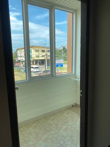 a room with two windows and a view of a street at U Dee Room and Coffee in Kanchanaburi