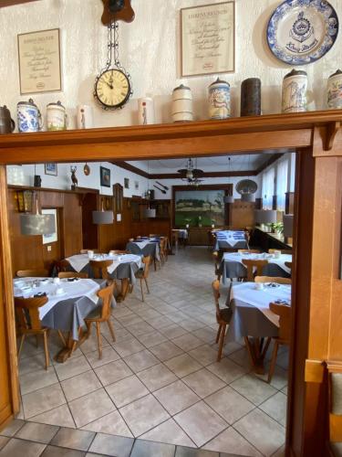 a dining room with tables and a clock on the wall at Hotel-Restaurant-Schlosskrug in Saarbrücken