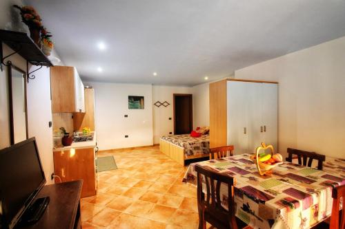 a living room with a table and a bedroom at Monolocale Cartuceddu 6b in Tertenìa