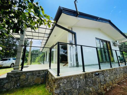 a house with glass windows and a stone wall at King's Horse Villa, Kuruwita in Ratnapura