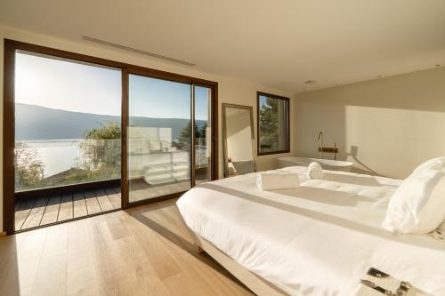 ヴェリエ・デュ・ラックにあるVilla Elegance - Vue Lacの大きな白いベッドと大きな窓のある寝室
