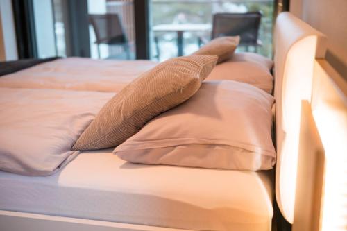 two pillows sitting on top of a bed at MOLO LIPNO RESIDENCE in Lipno nad Vltavou