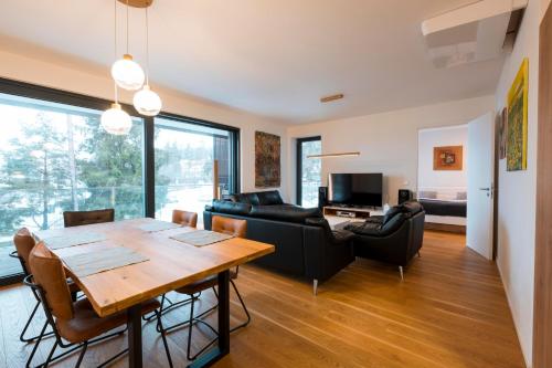 a living room with a table and a couch at MOLO LIPNO RESIDENCE in Lipno nad Vltavou