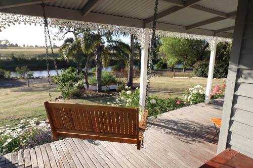 a porch swing with a view of a park at Bylands Cottage Historic Home - Tambo river views and pet friendly in Swan Reach